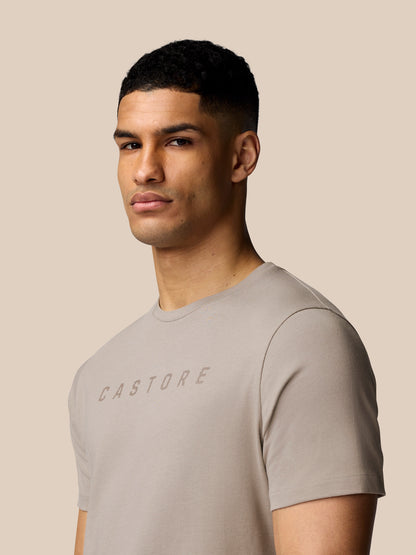 Close-up of male model wearing the Rock Grey graphic T shirt with Castore logo.