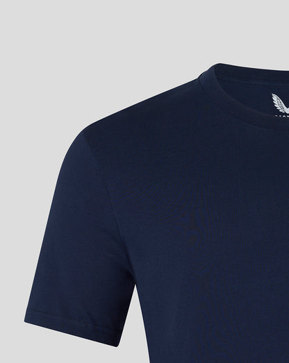 Close-up of navy T-shirt shoulder and neck with a white wing logo near the collar on the inside.