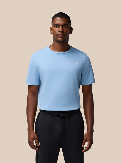 Front view of a man wearing a sky blue graphic training T shirt with a small left chest logo.