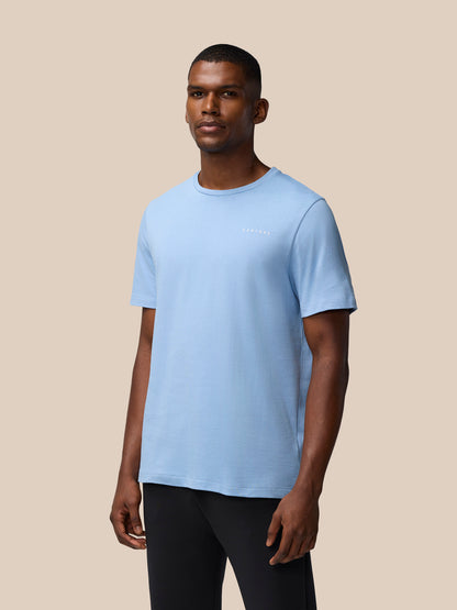 Man wearing sky blue graphic training T shirt with small white logo on the chest