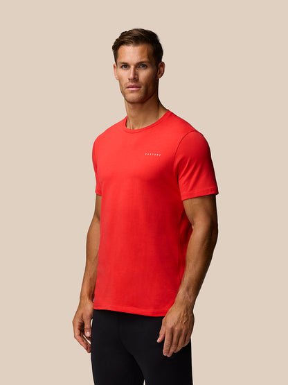 Male model wearing bright red graphic training t shirt with a small Castore logo on chest