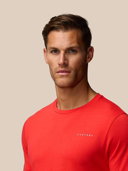 Close-up of a man wearing a red graphic training T-shirt with a small white logo on the chest