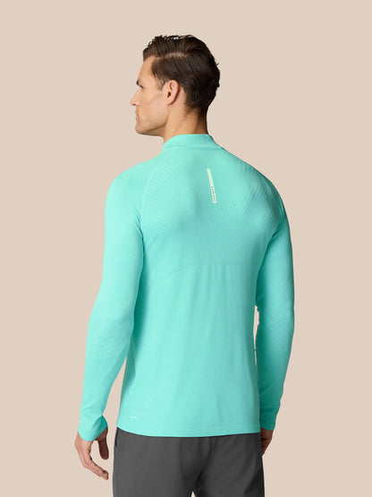 Back view of Flow Training 1/4 Zip Top in light aqua on a model, showing seamless back panels and Castore branding.