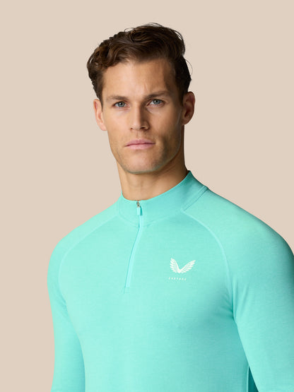 Male model in light aqua Flow Training 1/4 Zip Top front view with quarter zip and Castore logo on chest.