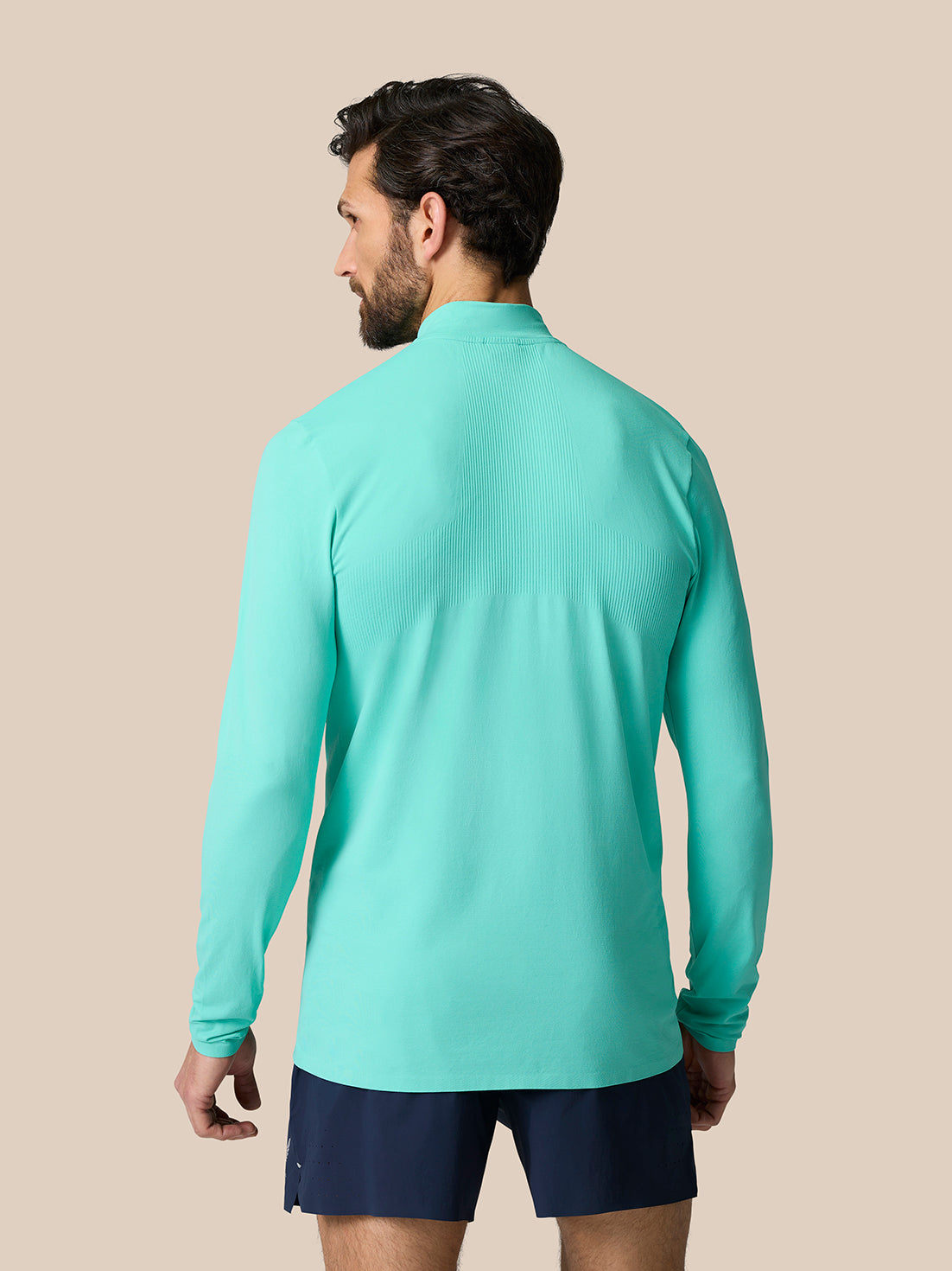 Model wearing light aqua Zone Training 1/4 Zip Top, back view showing ribbed upper back panel and long sleeves
