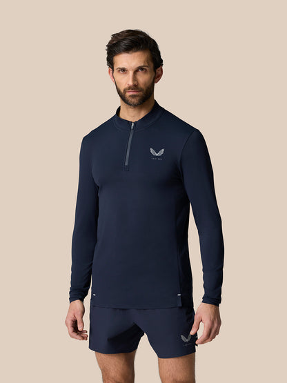 Male model wearing midnight navy Zone Training 1/4 Zip Top with high neck and front zip and chest logo