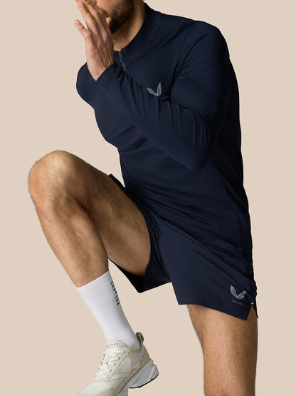 Male model in navy Zone Training 1/4 Zip Top in motion with chest logo and zip neck