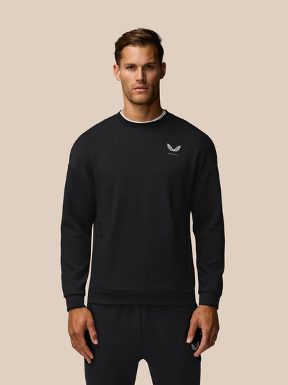 Front view of a man in a black Travel Lifestyle Sweatshirt focusing on the left chest logo and relaxed fit.