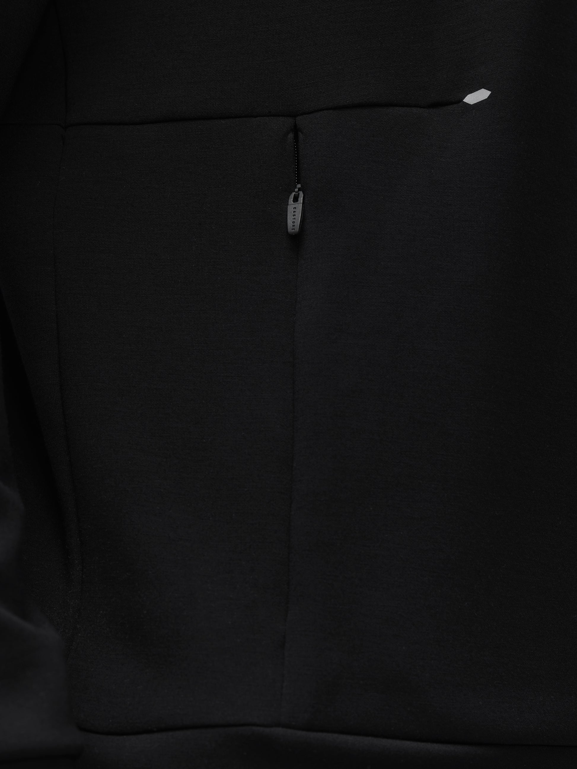 Close-up of black fabric on a Travel Lifestyle Sweatshirt showing a vertical front zip pull along a seam