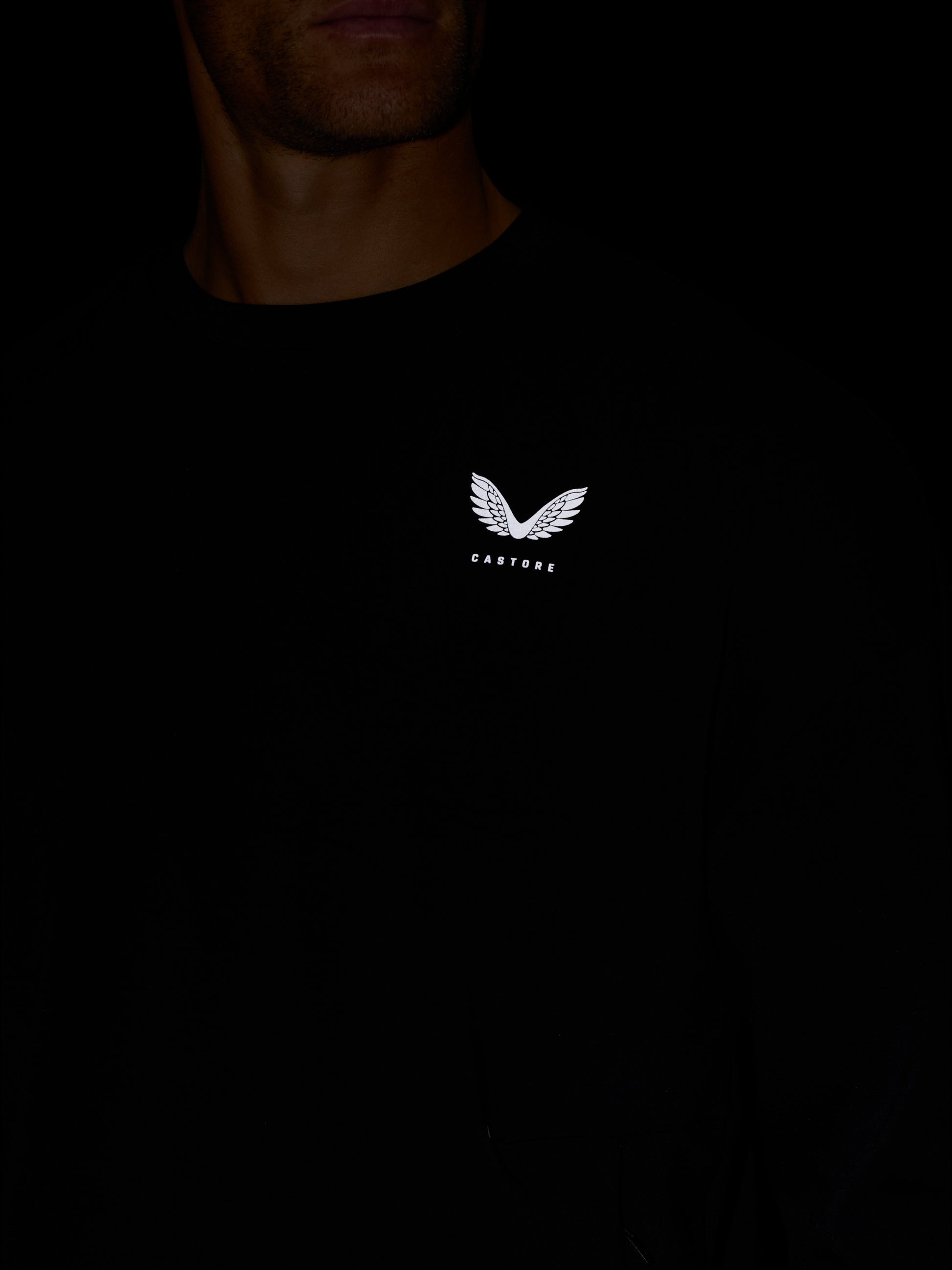 Person wearing black Crew Neck Sweatshirt with white Castore logo on the chest