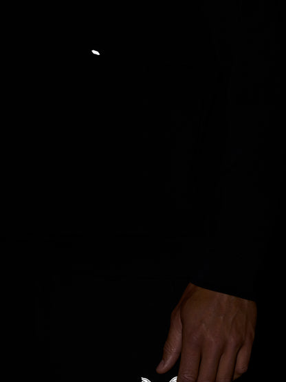 Small white Castore wing logo on black fabric near the hem
