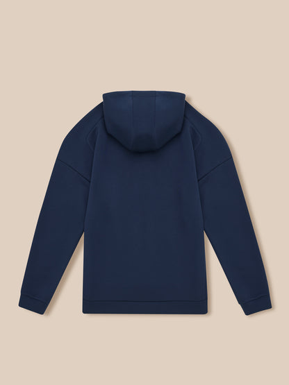Back view of navy Travel Lifestyle Zip Hoodie with hood up on beige background.