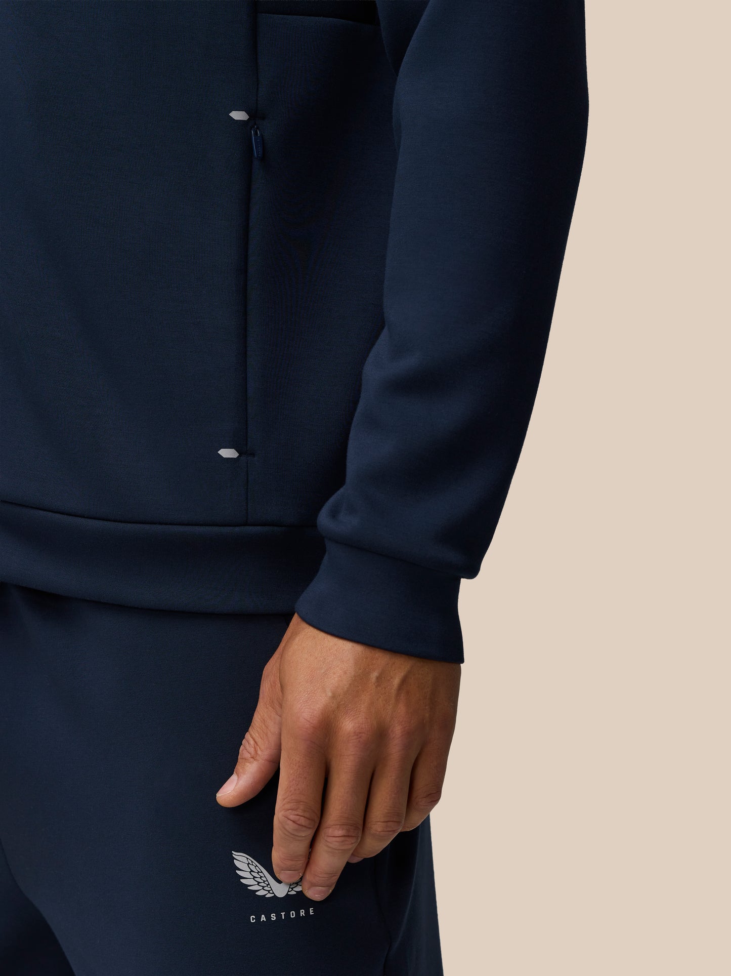 Close-up of navy Travel Lifestyle Zip Hoodie highlighting a zip pocket and Castore branding