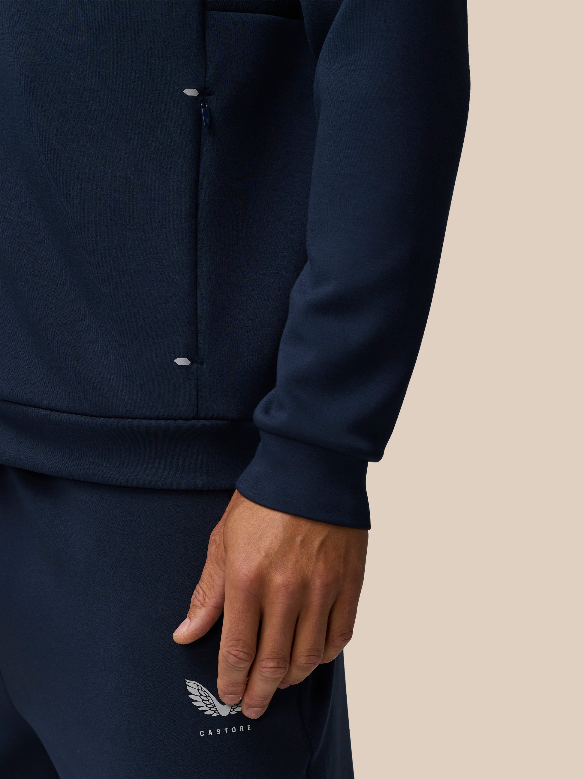 Close-up of navy Travel Lifestyle Zip Hoodie highlighting a zip pocket and Castore branding