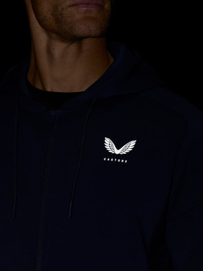 Close-up of navy Travel Lifestyle Zip Hoodie with visible zipper and Castore crest on the chest