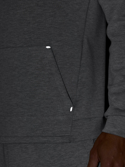 Detail of dark grey hoodie showing front pocket seam and textured fabric