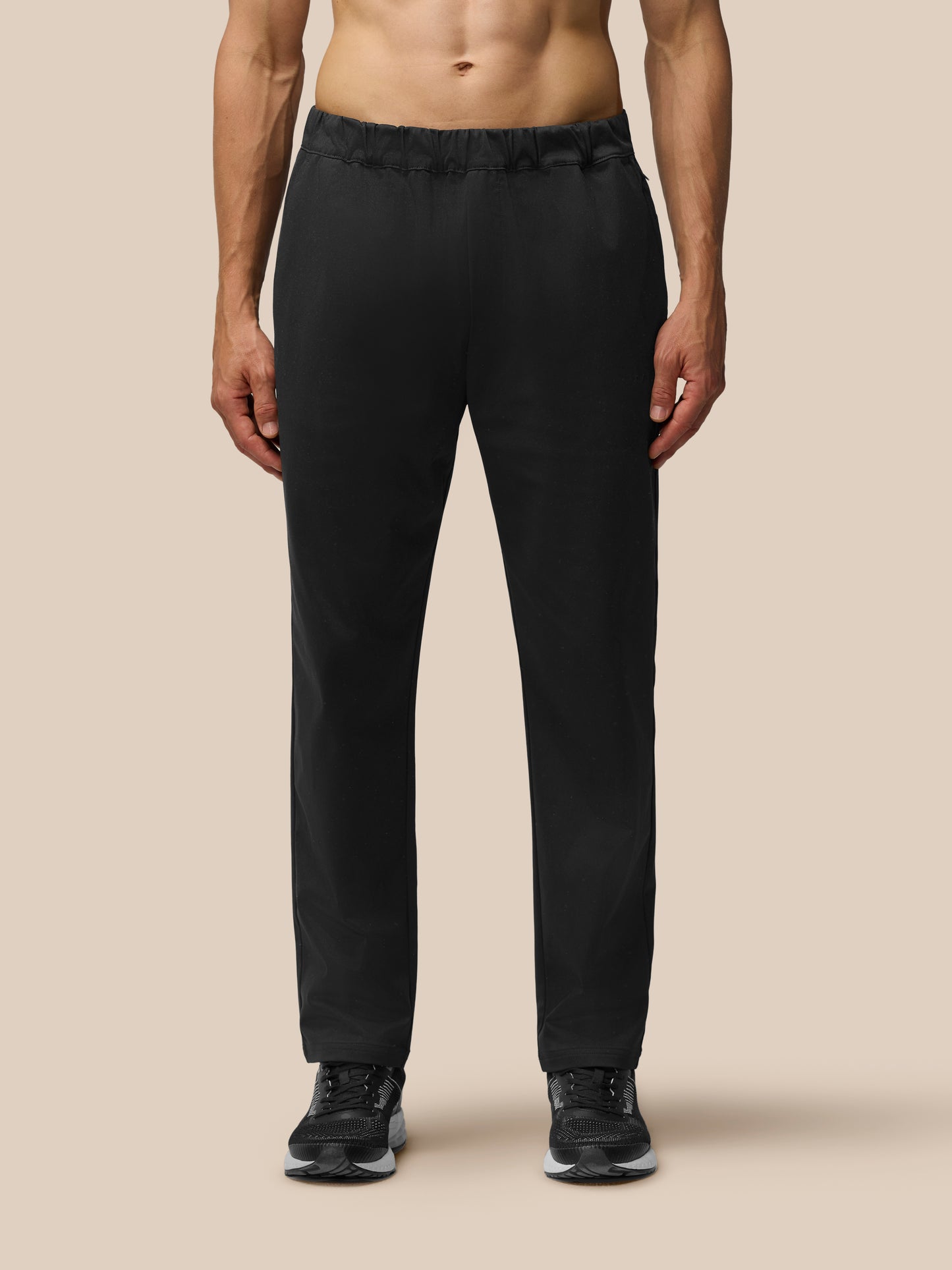 Back view of a man wearing black tailored trousers with elastic waist and back yoke zipped pocket