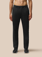 Back view of a man wearing black tailored trousers with elastic waist and back yoke zipped pocket