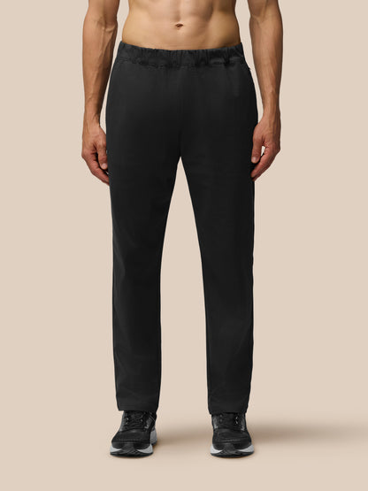 Back view of a man wearing black tailored trousers with elastic waist and back yoke zipped pocket