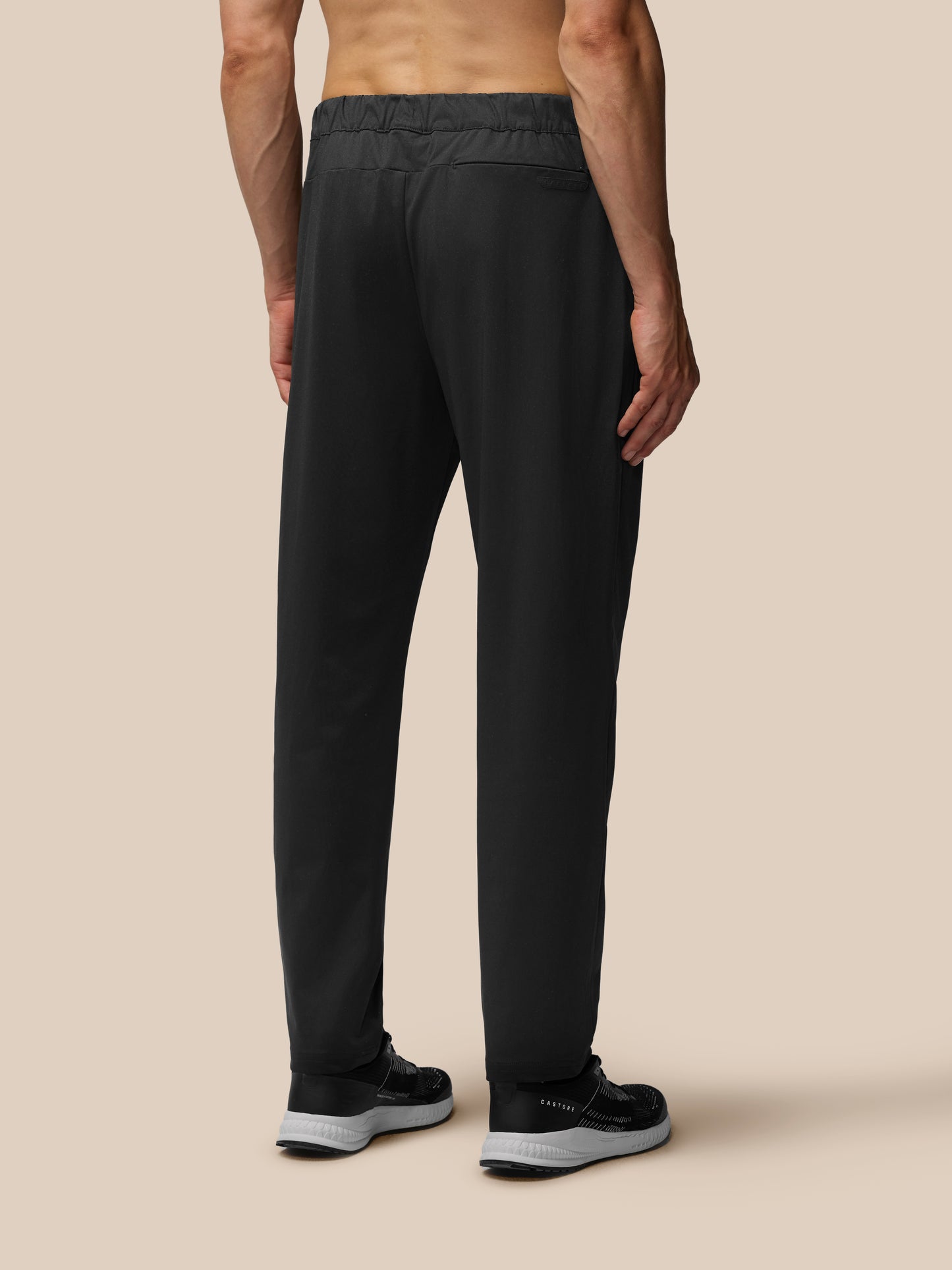 Rear view of a man in black tailored trousers with back pocket and sneakers