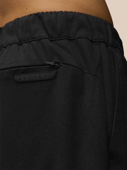 Close-up of black tailored trousers waist showing back yoke zip pocket and Castore back pocket badge.