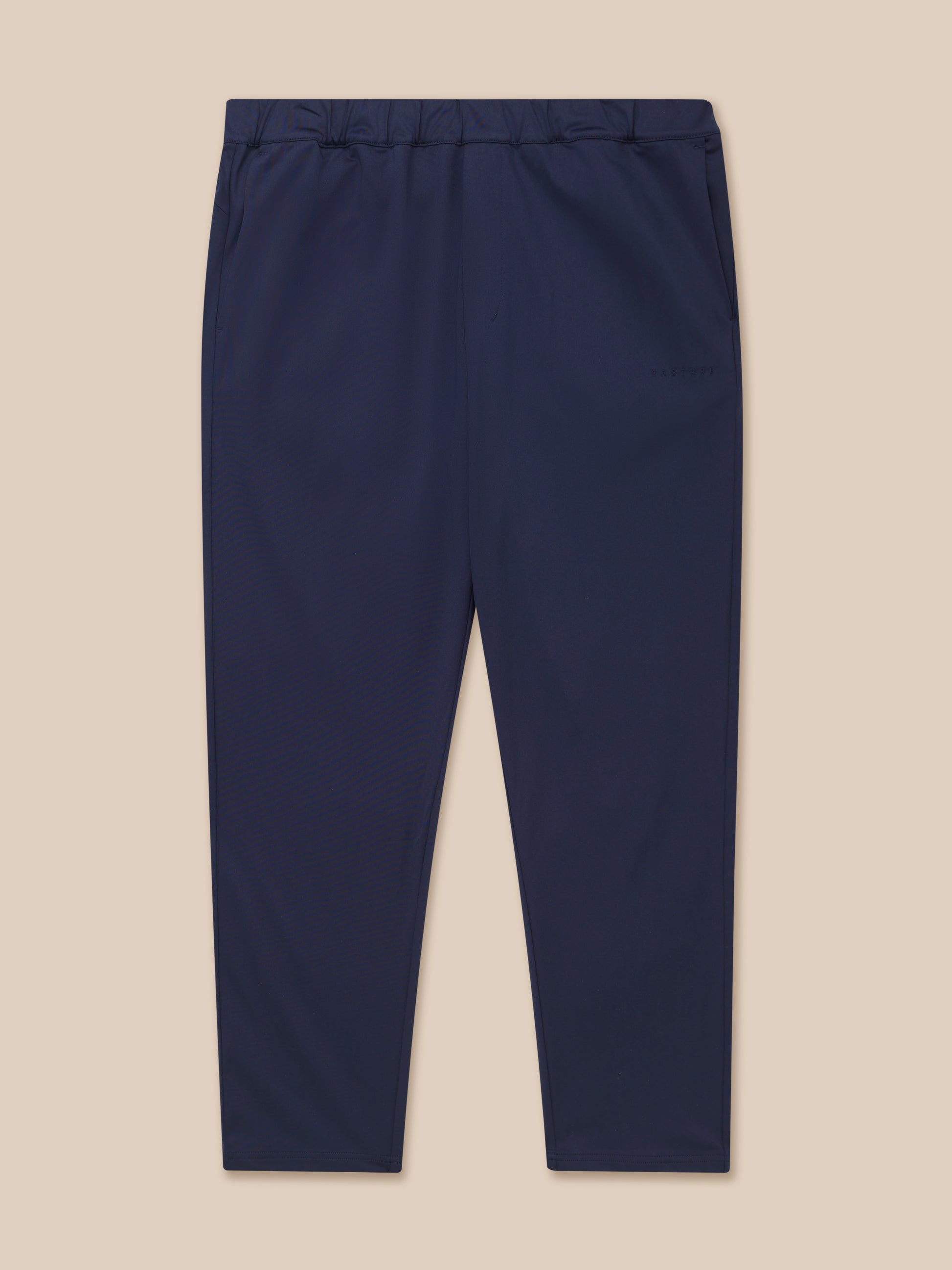Navy tailored trousers shown from the back waist with elastic waistband and back yoke zipped pocket, Castore branding on the left leg