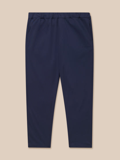 Navy tailored trousers shown from the back waist with elastic waistband and back yoke zipped pocket, Castore branding on the left leg