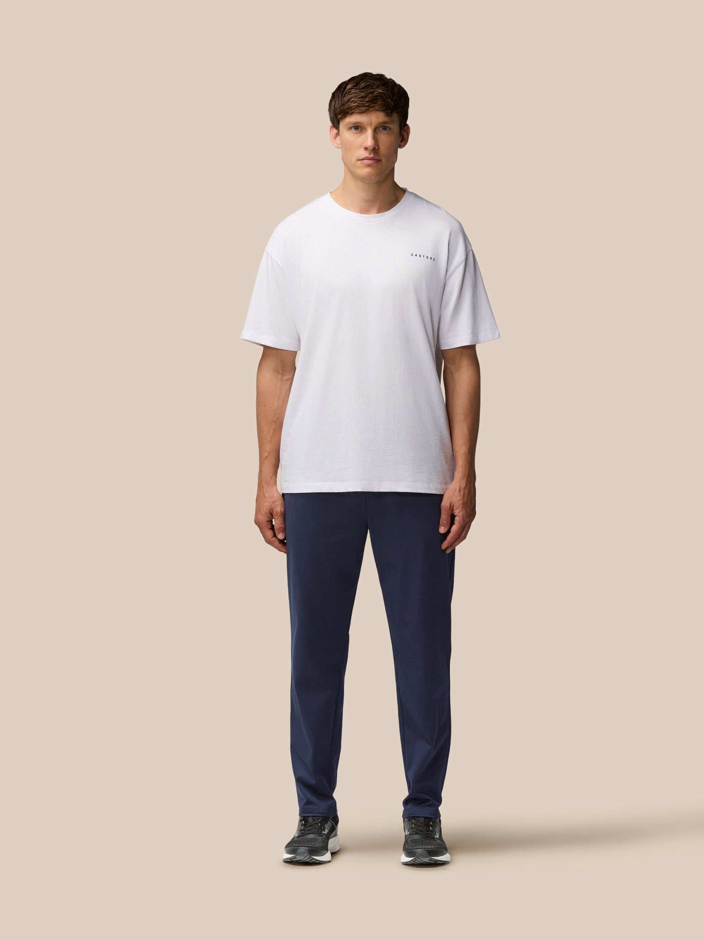 Male model wearing navy Elevated Lifestyle Tailored Trousers with white t shirt