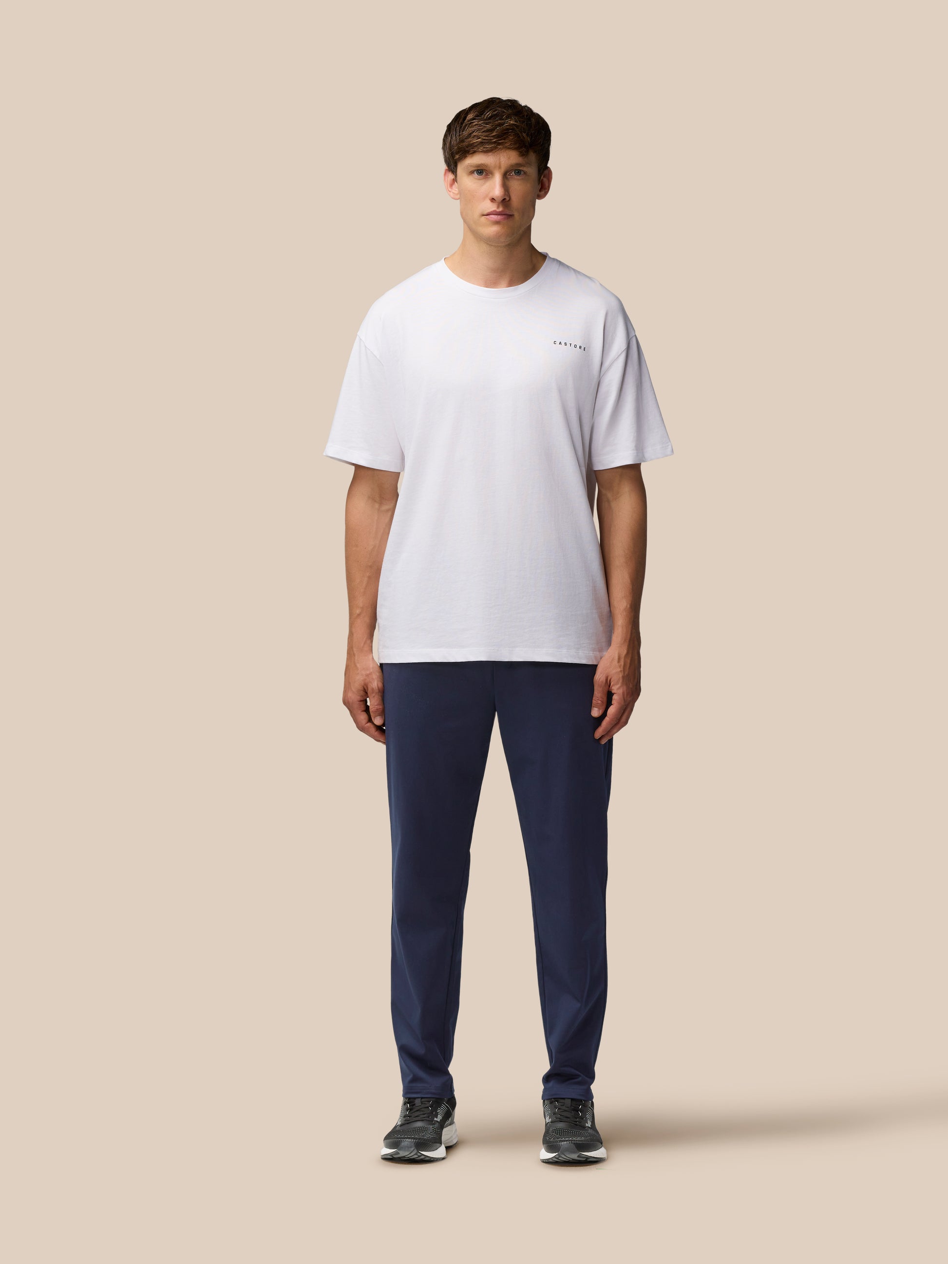 Male model wearing navy Elevated Lifestyle Tailored Trousers with white t shirt