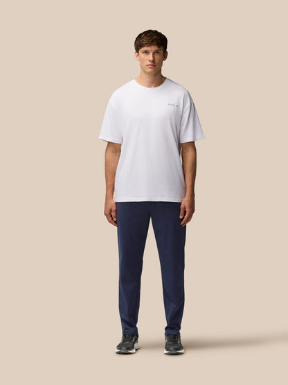 Male model wearing navy Elevated Lifestyle Tailored Trousers with white t shirt