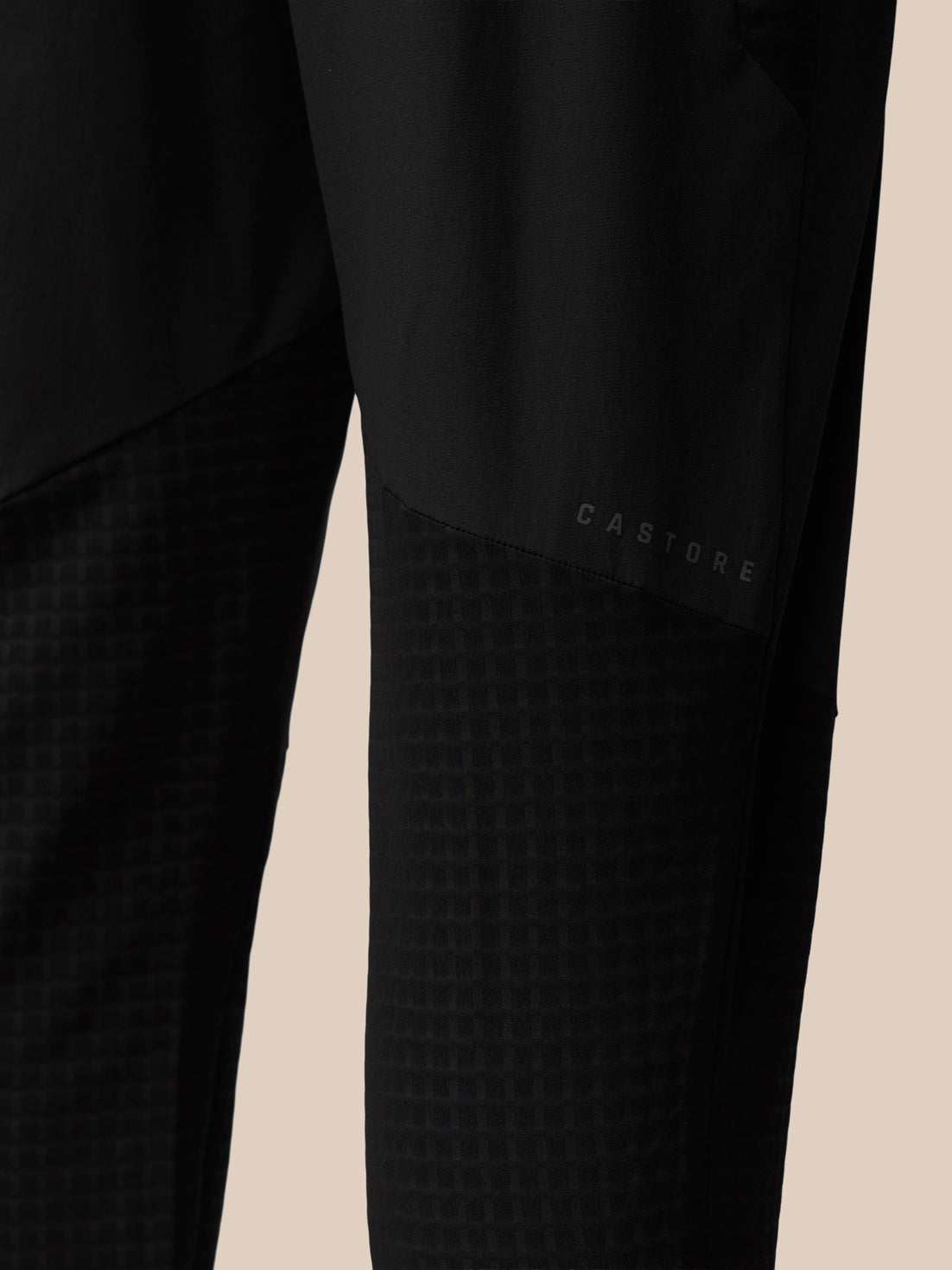 Rear close-up of black Flex Winterised Woven Joggers with Castore emblem on the thigh panel.