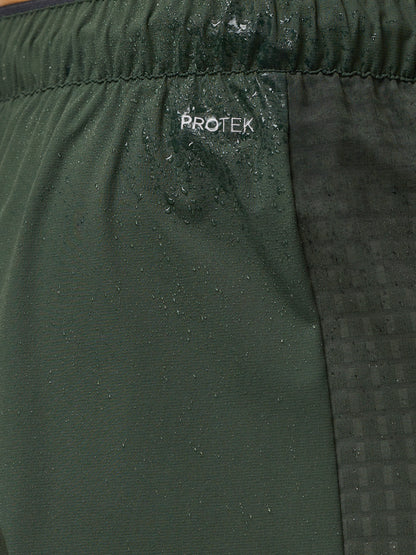Close-up of dark green Flex Winterised Joggers fabric showing an elastic waistband and ProTek branding with water droplets.