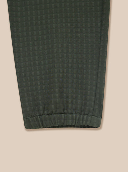 Close-up of dark green woven fabric on Flex Winterised Woven Joggers showing a subtle grid pattern and elastic cuff