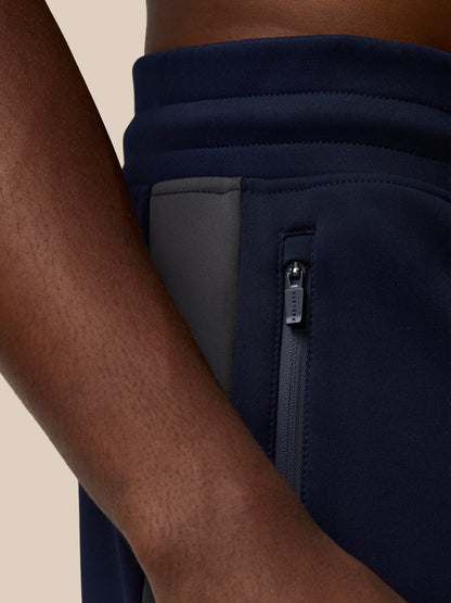 Close up of navy Flex Thermo Pant waist showing a zipped side pocket and Castore branding