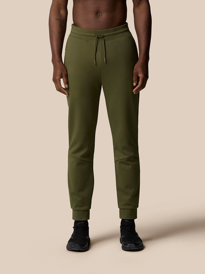 Front view of a model wearing olive green Flex Thermo pants with drawstring waist and ribbed cuffs