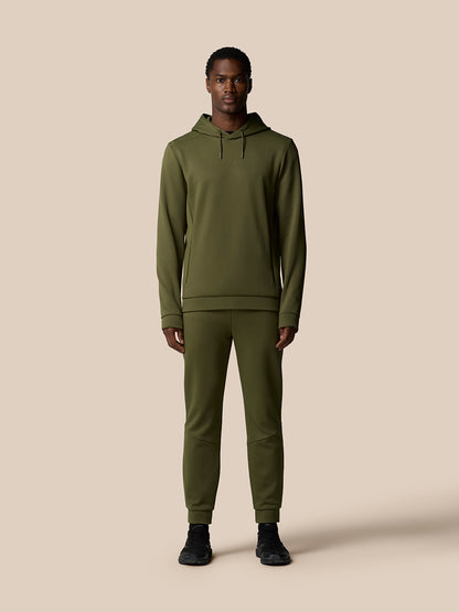 Full body shot of a man wearing an olive green Flex Thermo tracksuit with hoodie and joggers