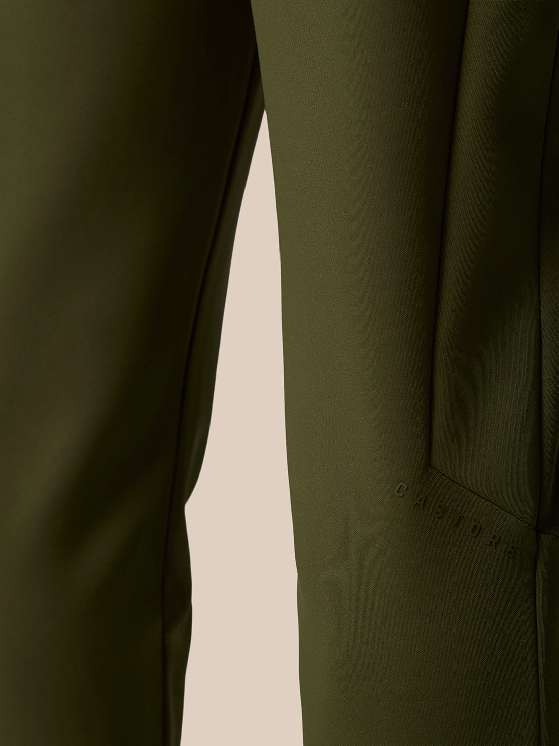 Close-up of the olive green Flex Thermo Pant leg showing a zippered pocket and smooth performance fabric.