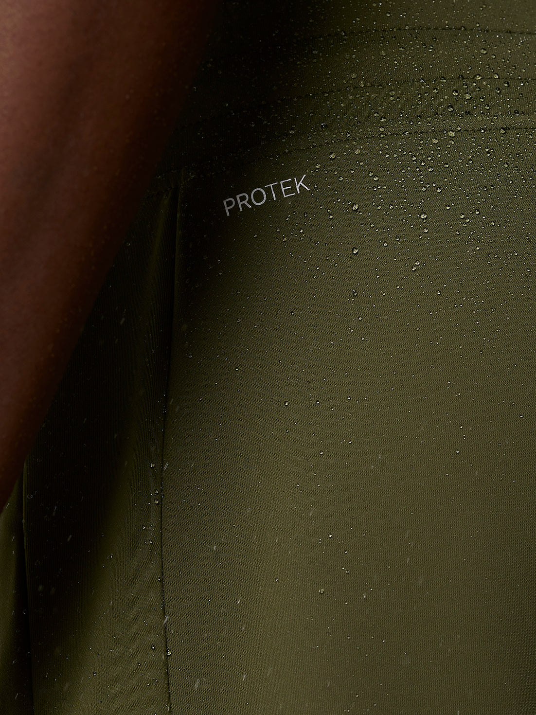 Close-up of olive green ProTek water resistant fabric with branding on the leg