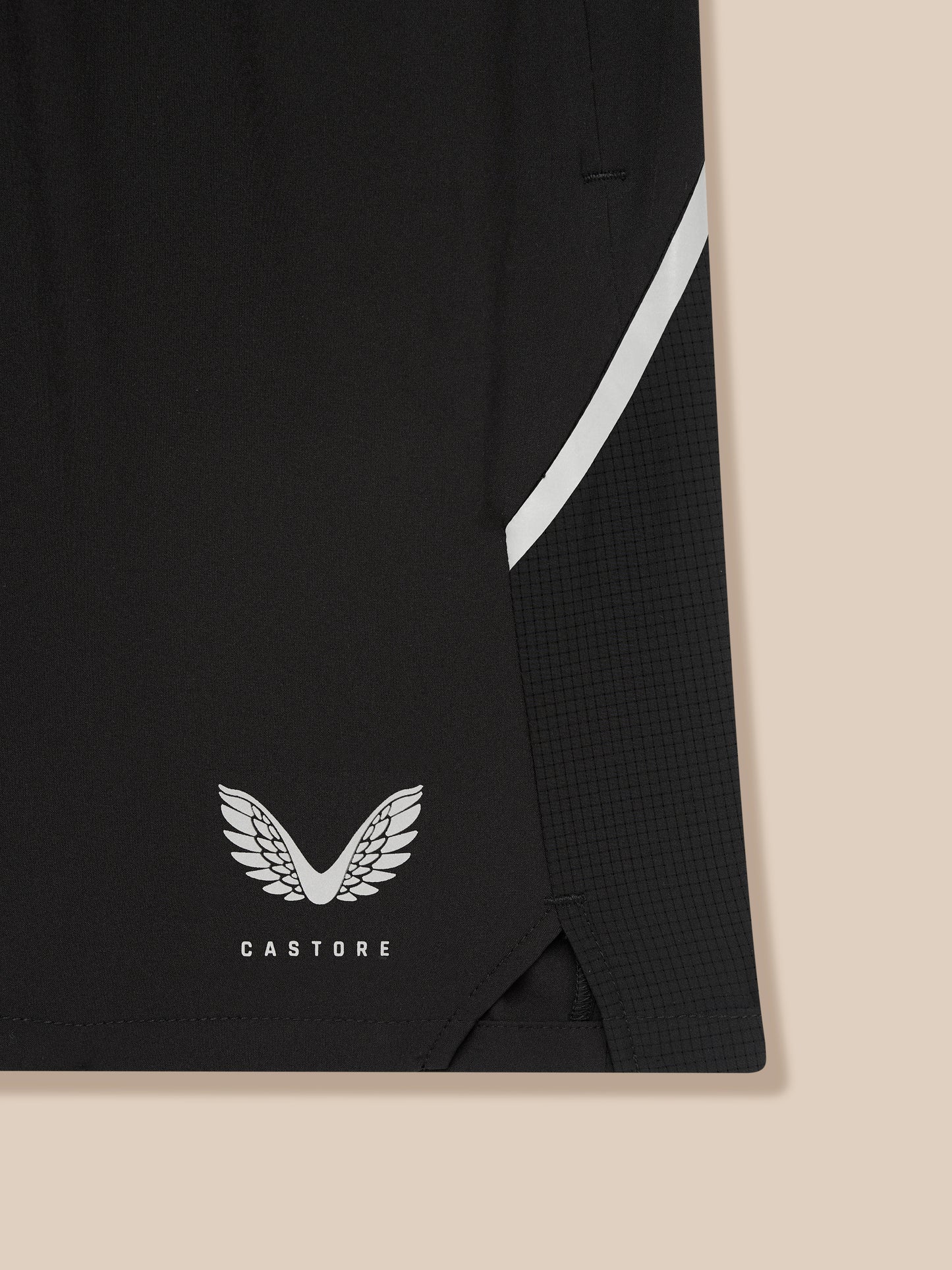 Close-up of Apex Training 6-Inch Shorts in black fabric with a white diagonal stripe and Castore logo at the hem