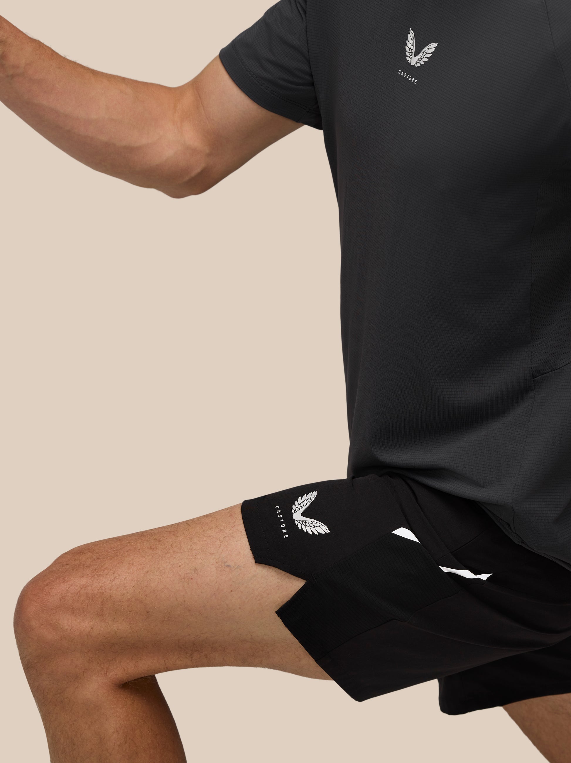 Male model wearing black Apex Training 6 inch shorts with logo on the leg and textured fabric.