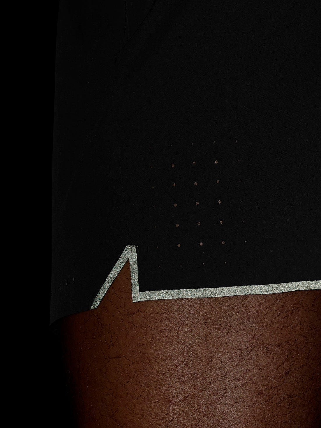 Close-up of dark Zone Training LVS 5 inch shorts showing a zip pocket and textured fabric.