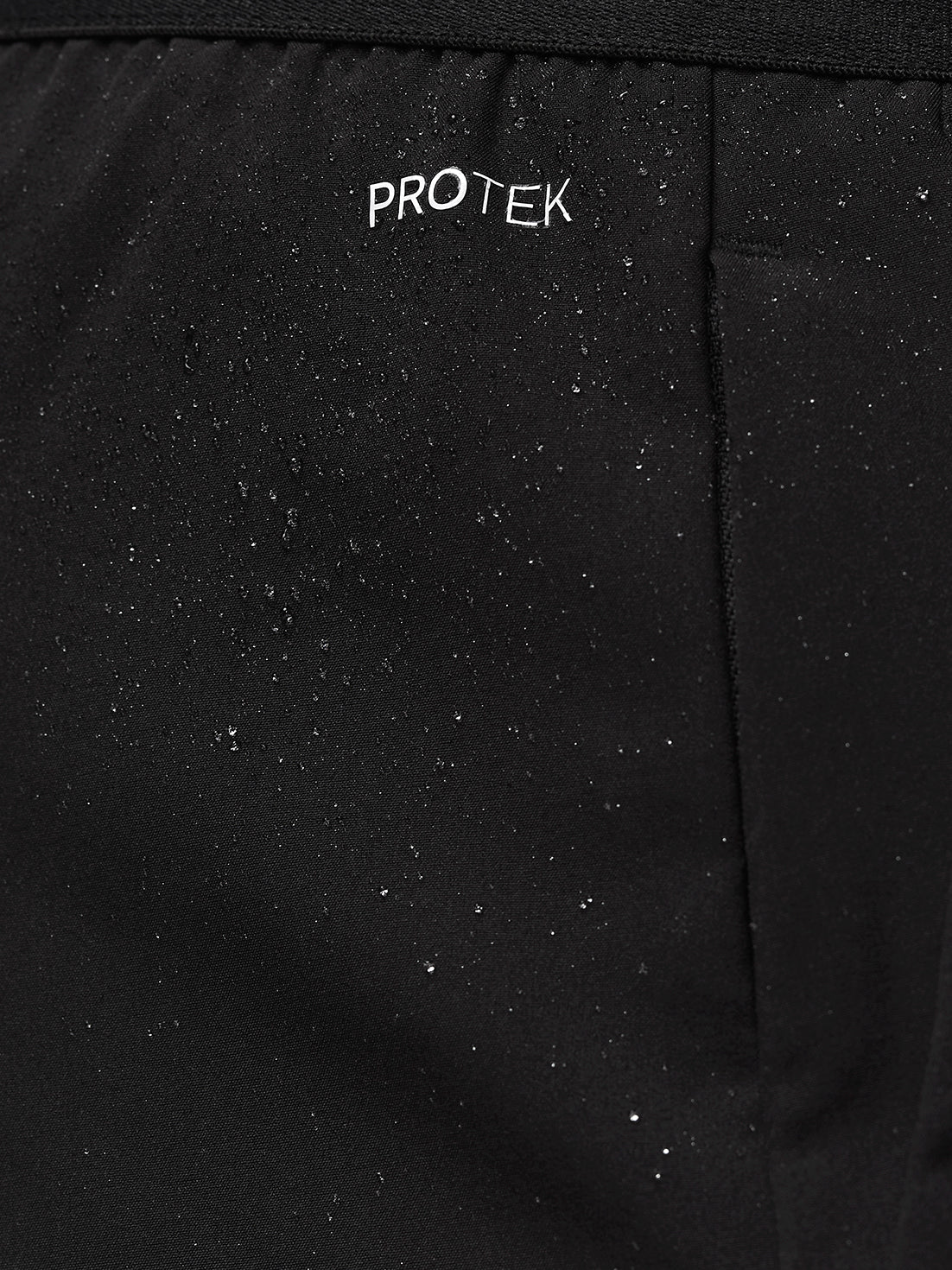 Close-up of black ProTek fabric with water droplets and subtle branding