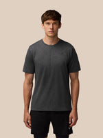 Male model wearing a dark gray Flow Training Engineered Knit T Shirt with subtle geometric pattern