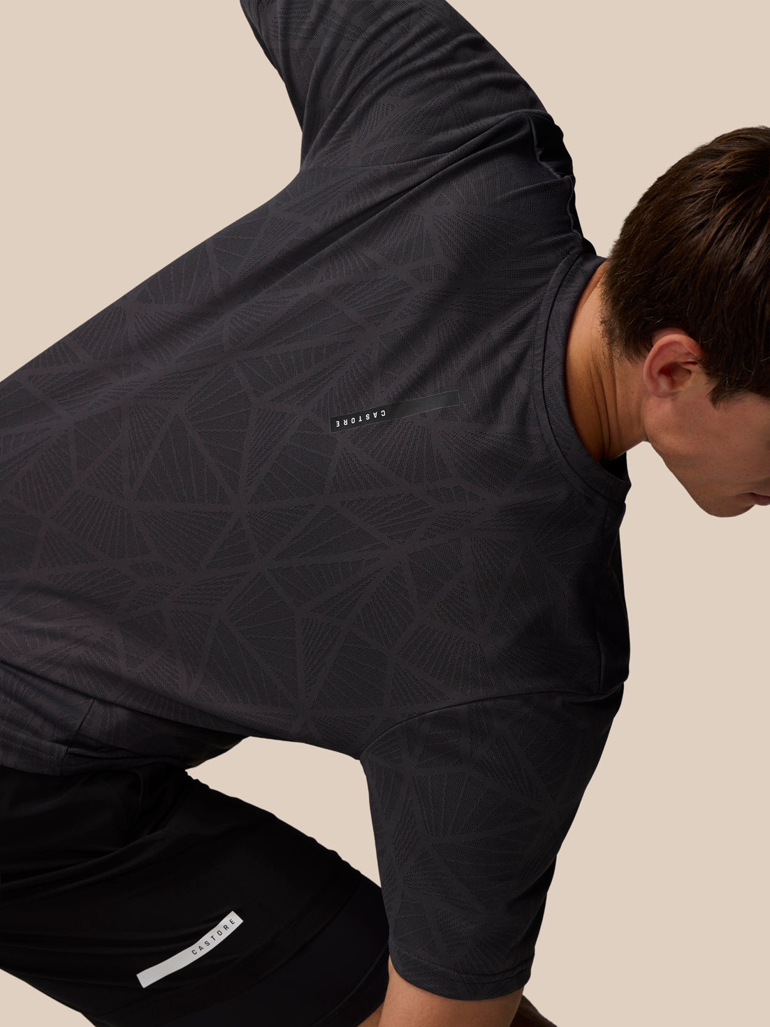 Flow Training Engineered Knit T Shirt in black worn by a model showing geometric knit pattern and Castore logo on the left chest