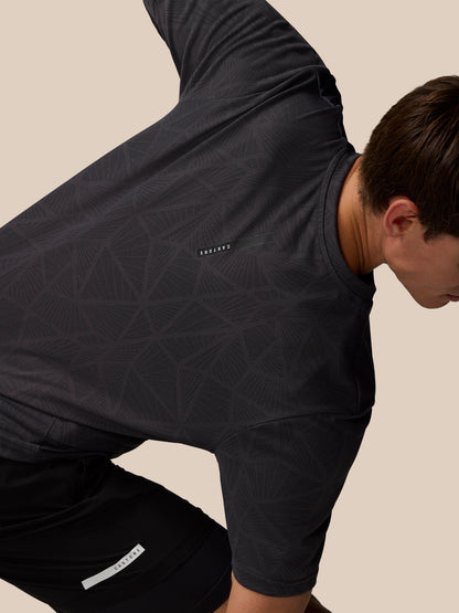 Flow Training Engineered Knit T Shirt in black worn by a model showing geometric knit pattern and Castore logo on the left chest