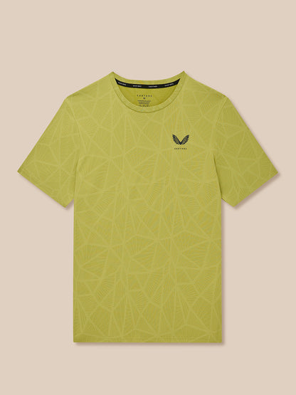 Flat lay of Flow Training Engineered Knit T Shirt in mustard with geometric knit print and Castore logo.