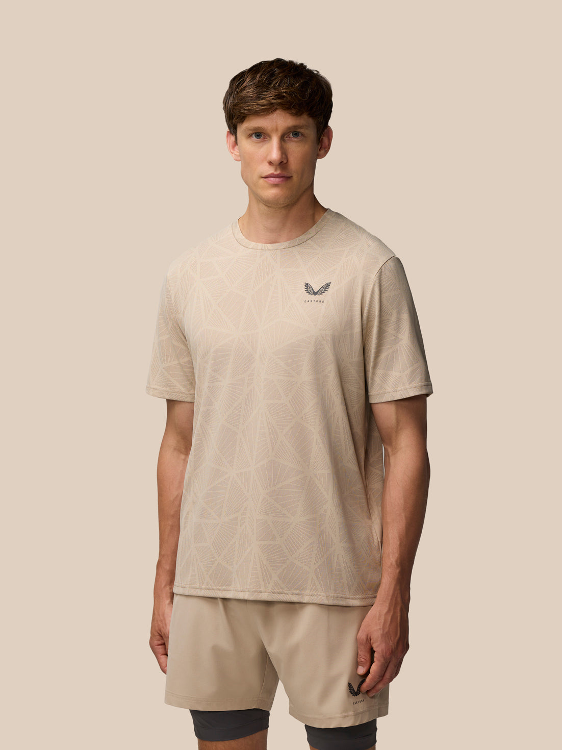 Flow Training Engineered Knit T Shirt Mushroom Black worn by a male model with beige geometric knit and Castore logo on left chest
