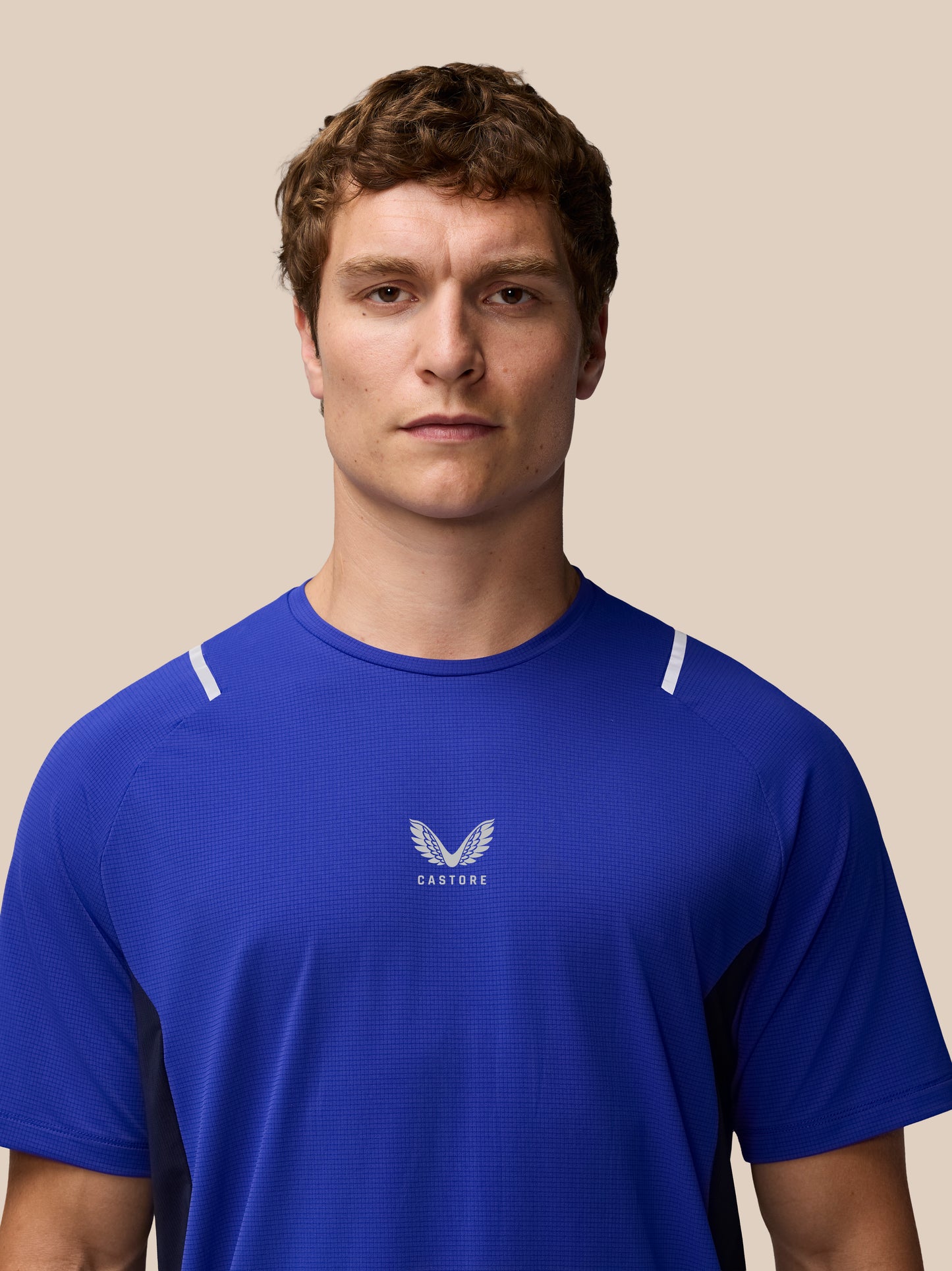 Front view of a man wearing azure blue Apex Training T Shirt with Castore logo on the chest