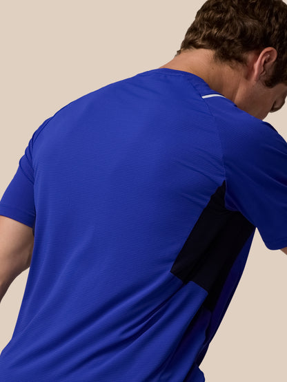 Close up of a person wearing the Azure blue Apex Training T-Shirt, highlighting textured fabric and a white neck trim from the back.