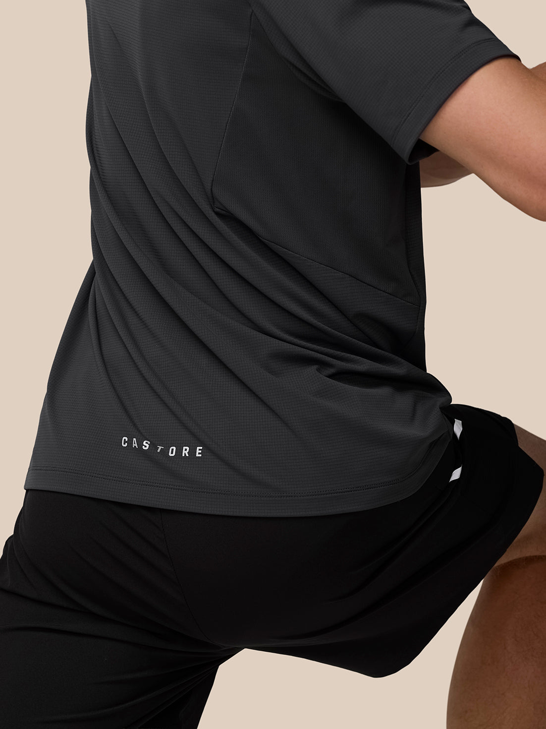 Full-body shot of man in gunmetal Apex Training T-Shirt with reflective shoulders and black shorts
